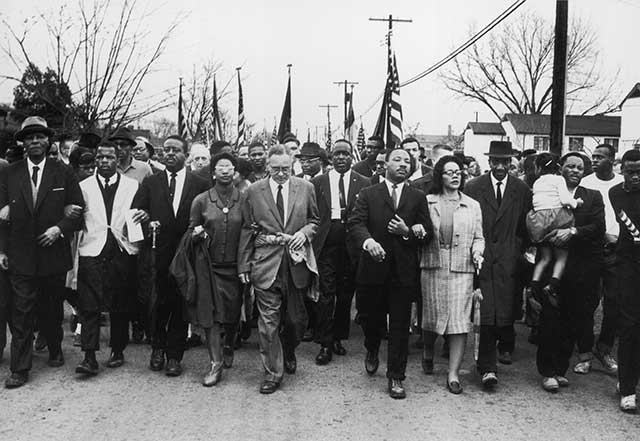Martin Luther King and his wife Coretta Scott King lead a black voting rights march from Selma, Alabama, to the state capital in Montgomery in 1965. (Photo by William Lovelace/Express/Getty Images)