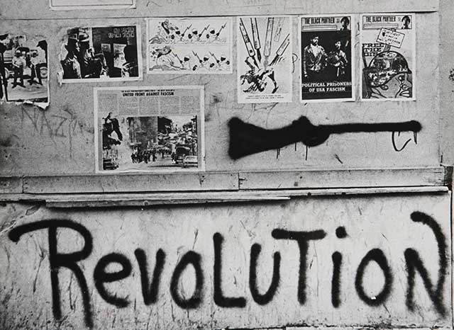  Amplified by the Black Panthers, whose posters adorn a Baltimore wall in 1970, that note of violent opposition to authority still echoes loudly in underclass culture today. (ULLSTEIN BILD / GRANGER, NYC — ALL RIGHTS RESERVED.)
