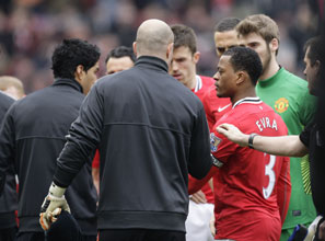 Liverpool's Luis Suarez (left) refuses to shake the hand of Manchester United's Patrice Evra, who had accused him of racial taunts.